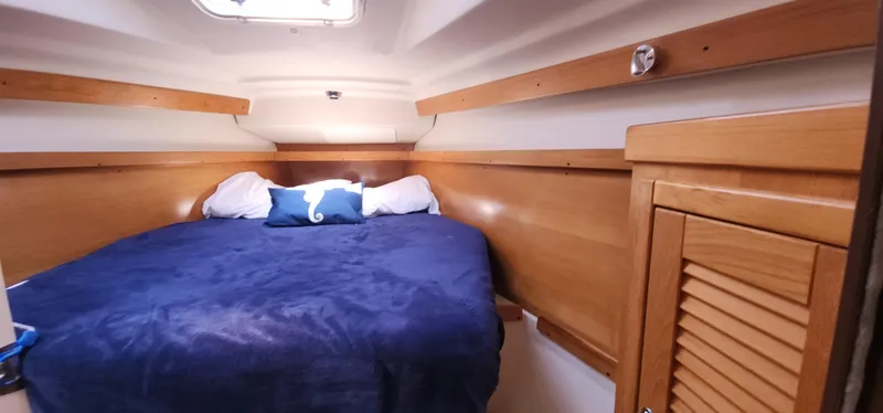 Janice Marie Yacht Photos Pics Cozy cabin interior of 2004 Catalina 350 Sloop with blue bedding and wooden accents.