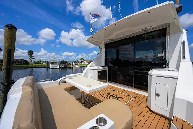 Ajac Cruiser Yacht Photos Pics 2015 Cruisers Cantius yacht with outdoor seating, docked under a clear blue sky.