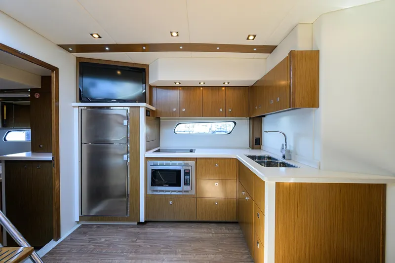 Ajac Cruiser Yacht Photos Pics 2015 Cruisers Cantius yacht kitchen with modern appliances, wood cabinetry, and sleek design.
