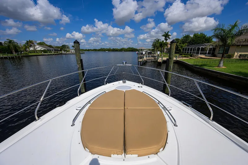 Ajac Cruiser Yacht Photos Pics 2015 Cruisers Cantius boat bow view on a sunny day, docked by a scenic river.