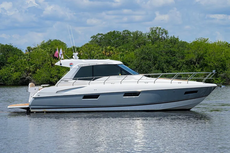 Ajac Cruiser Yacht Photos Pics 2015 Cruisers Cantius yacht on calm water with lush greenery background.