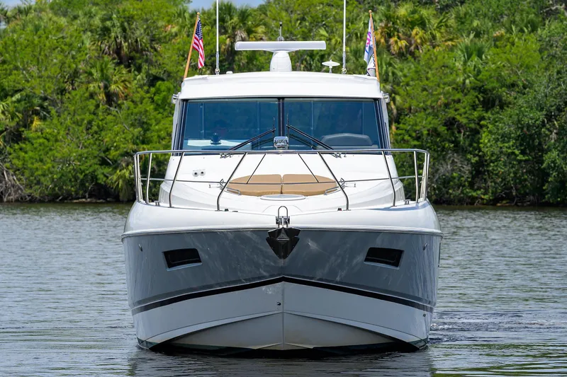 Ajac Cruiser Yacht Photos Pics 2015 Cruisers Cantius yacht on calm water, lush greenery in background.