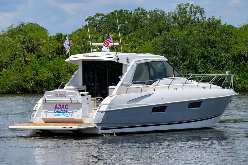 Ajac Cruiser Yacht Photos Pics 2015 Cruisers Cantius yacht on a serene waterway, surrounded by lush greenery.