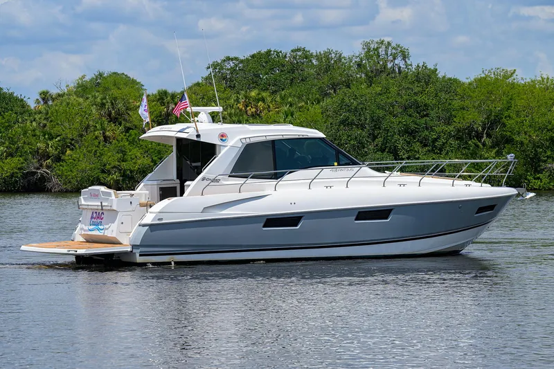 Ajac Cruiser Yacht Photos Pics 2015 Cruisers Cantius yacht on a serene river with lush greenery.