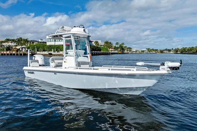  Yacht Photos Pics 2023 Everglades 243 Center Console boat on calm water, with scenic waterfront background.