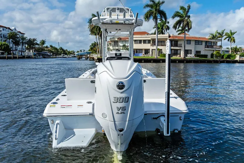  Yacht Photos Pics 2023 Everglades 243 Center Console boat on water, palm trees in background.
