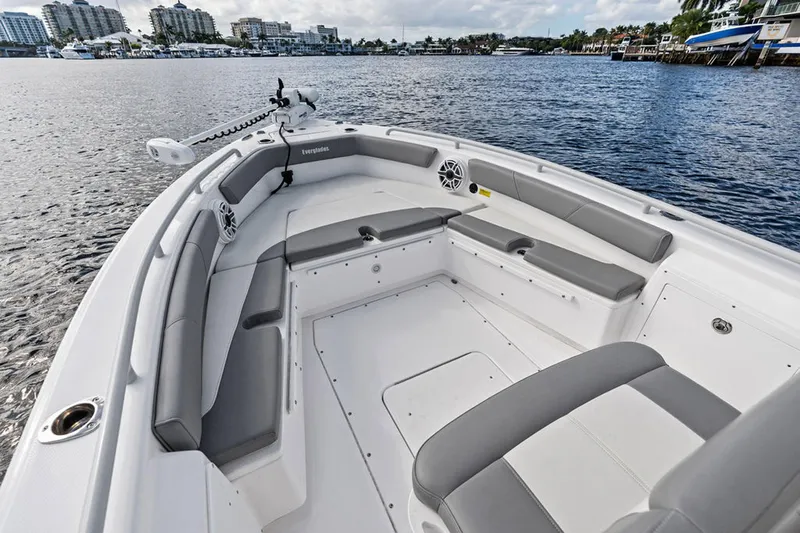  Yacht Photos Pics 2023 Everglades 243 Center Console boat interior with gray seating, docked by waterfront buildings.