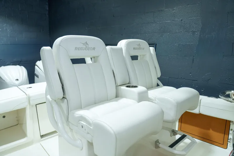  Yacht Photos Pics 2023 Regulator 28 boat interior with white cushioned seats and cup holder.