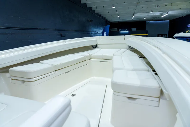  Yacht Photos Pics 2023 Regulator 28 boat interior with white cushioned seating in a showroom.