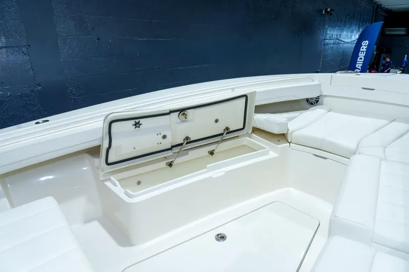  Yacht Photos Pics 2023 Regulator 28 boat interior with open storage compartment and cushioned seating.