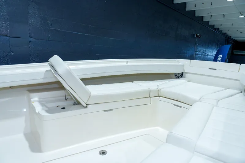  Yacht Photos Pics 2023 Regulator 28 boat interior with white cushioned seating and storage compartments.