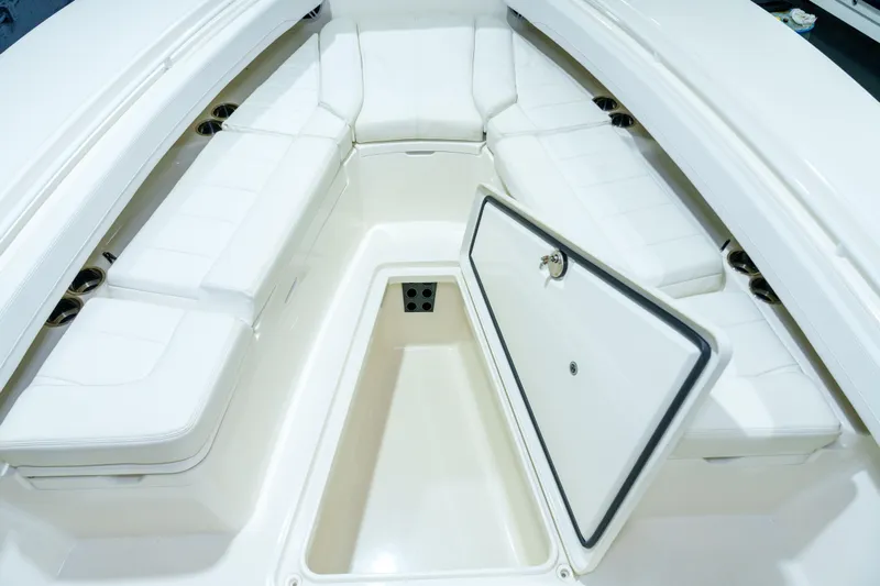  Yacht Photos Pics 2023 Regulator 28 boat interior with white cushioned seating and open storage compartment.