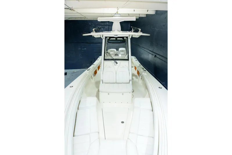  Yacht Photos Pics 2023 Regulator 28 boat interior with white seating and console in a garage.