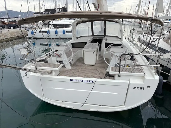 Blue Satellite Yacht Photos Pics 2019 Beneteau Oceanis 46.1 sailboat docked in marina, featuring dual steering wheels.