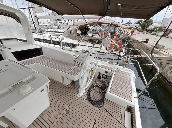 Blue Satellite Yacht Photos Pics 2019 Beneteau Oceanis 46.1 yacht cockpit with teak flooring and steering wheel.