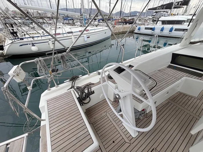 Blue Satellite Yacht Photos Pics Cockpit of 2019 Beneteau Oceanis 46.1 yacht, featuring a sleek steering wheel and wooden deck.
