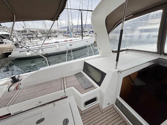 Blue Satellite Yacht Photos Pics 2019 Beneteau Oceanis 46.1 yacht cockpit with wooden deck, docked in marina.
