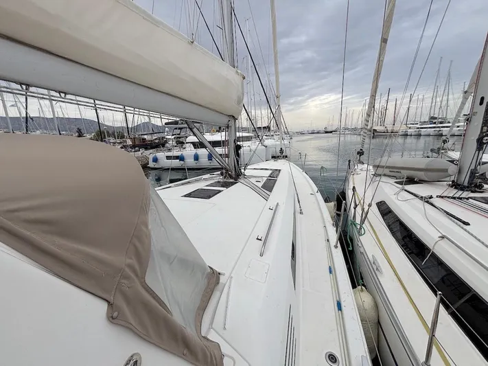 Blue Satellite Yacht Photos Pics 2019 Beneteau Oceanis 46.1 sailboat docked in a marina, surrounded by other boats.