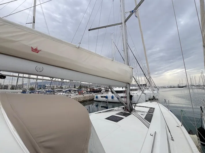 Blue Satellite Yacht Photos Pics 2019 Beneteau Oceanis 46.1 sailboat docked at marina under cloudy sky.