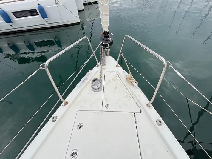 Blue Satellite Yacht Photos Pics Bow of 2019 Beneteau Oceanis 46.1 sailboat, docked in calm waters.