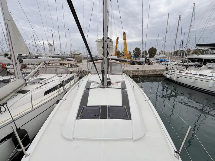Blue Satellite Yacht Photos Pics 2019 Beneteau Oceanis 46.1 sailboat docked in a marina, surrounded by other yachts.
