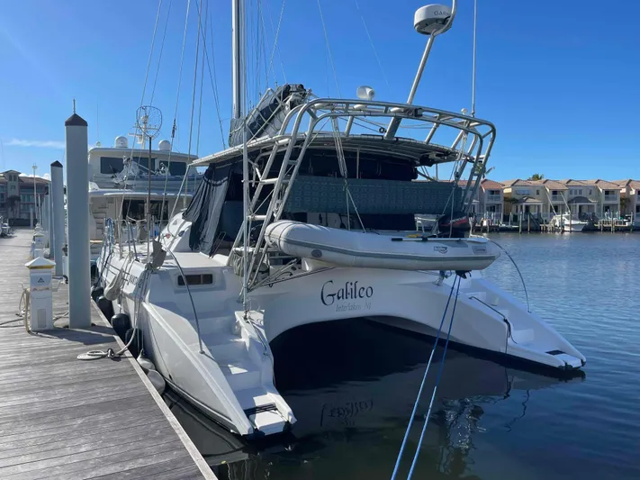 Galileo Yacht Photos Pics 2000 Manta 42 Catamaran docked at marina, clear blue sky, calm water.