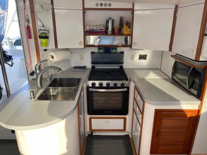 Galileo Yacht Photos Pics Compact kitchen in a 2000 Manta 42 Catamaran with stove, sink, and microwave.