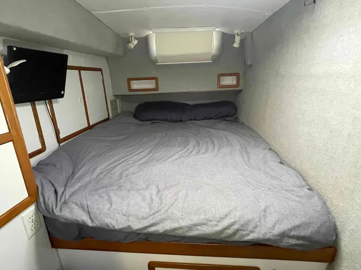 Galileo Yacht Photos Pics Cozy bedroom in 2000 Manta 42 Catamaran with gray bedding and small TV.
