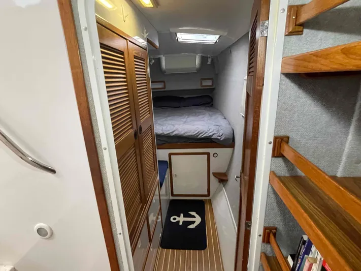 Galileo Yacht Photos Pics Interior of 2000 Manta 42 Catamaran cabin with bed, wooden shelves, and nautical decor.
