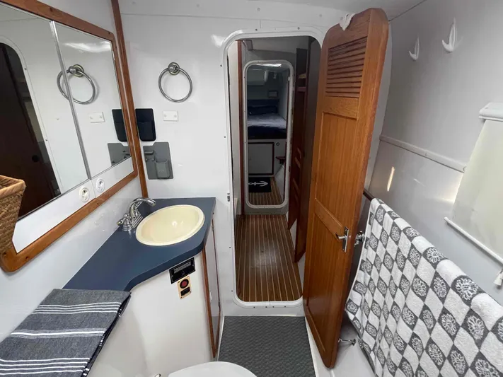 Galileo Yacht Photos Pics Bathroom interior of 2000 Manta 42 Catamaran with sink, mirror, and wooden door.