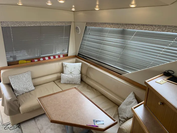  Yacht Photos Pics Interior of 2000 Bayliner 3988 yacht with beige seating and wooden table.