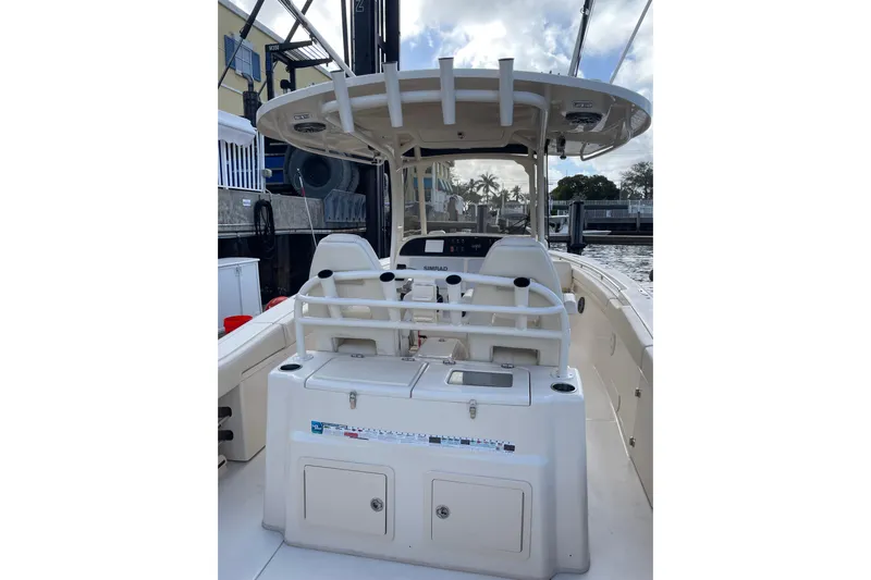  Yacht Photos Pics 2023 Grady-White Canyon 306 boat interior with helm and seating, docked by the water.