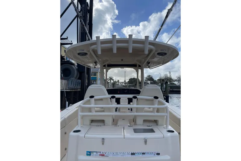  Yacht Photos Pics 2023 Grady-White Canyon 306 boat interior with seating and helm, docked under cloudy sky.