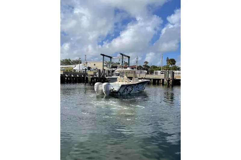  Yacht Photos Pics 2023 Grady-White Canyon 306 boat docked in a marina under a cloudy sky.