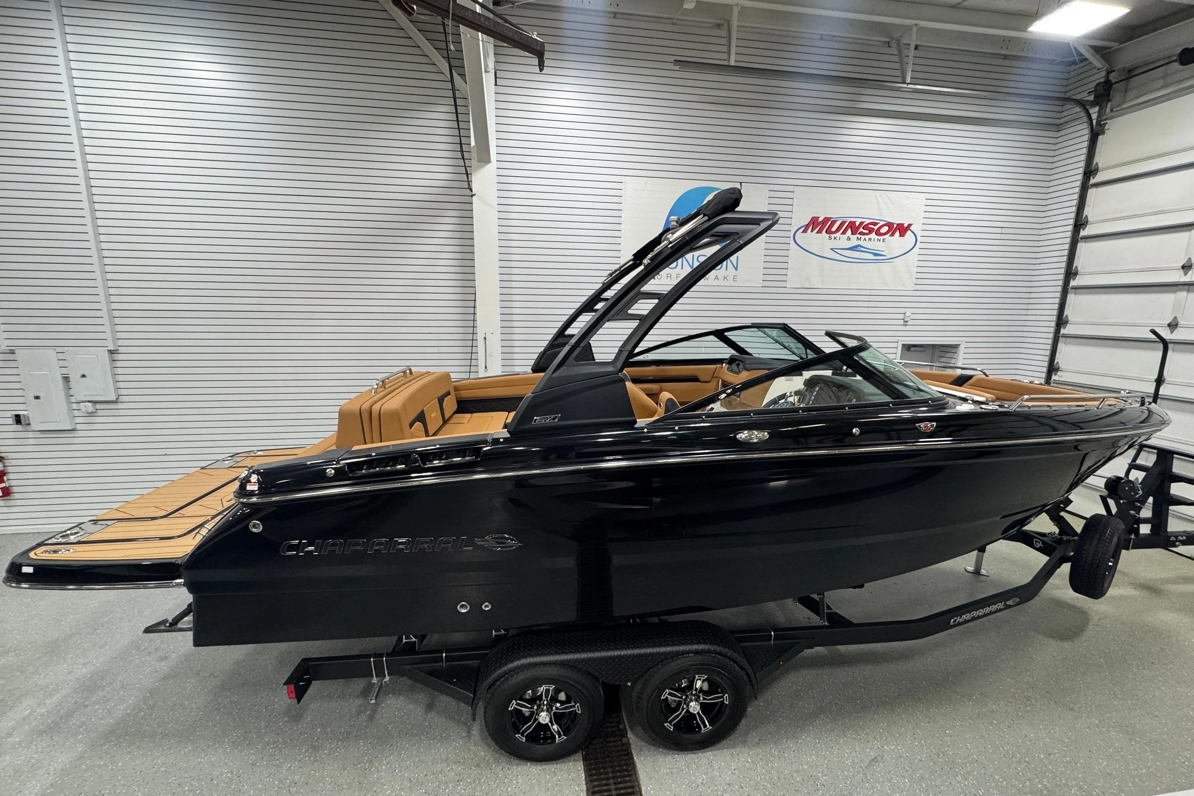 2026 Chaparral 6 SSX boat in showroom, black exterior, tan interior, on trailer.