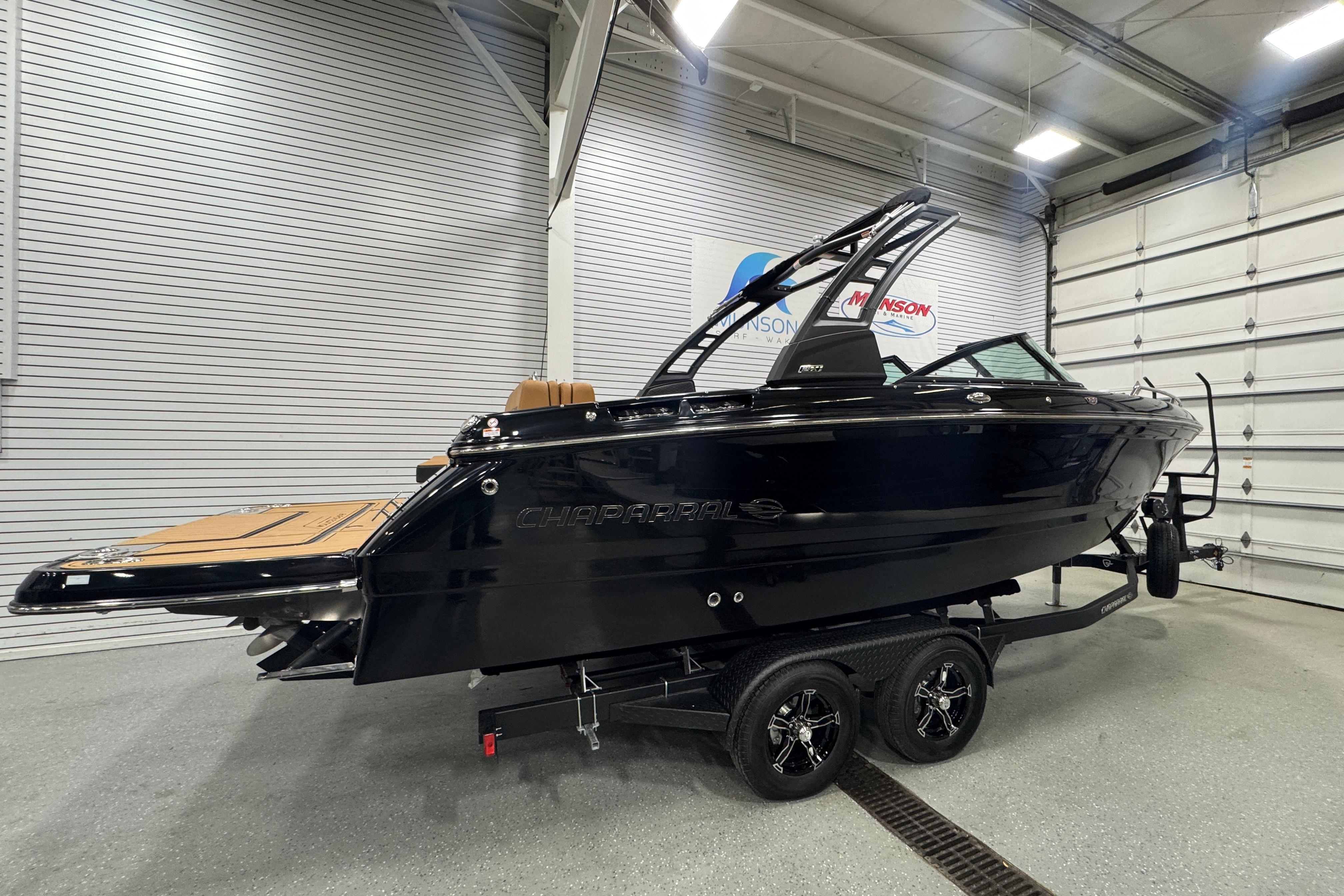 2026 Chaparral 6 SSX boat in showroom, sleek black design on trailer.