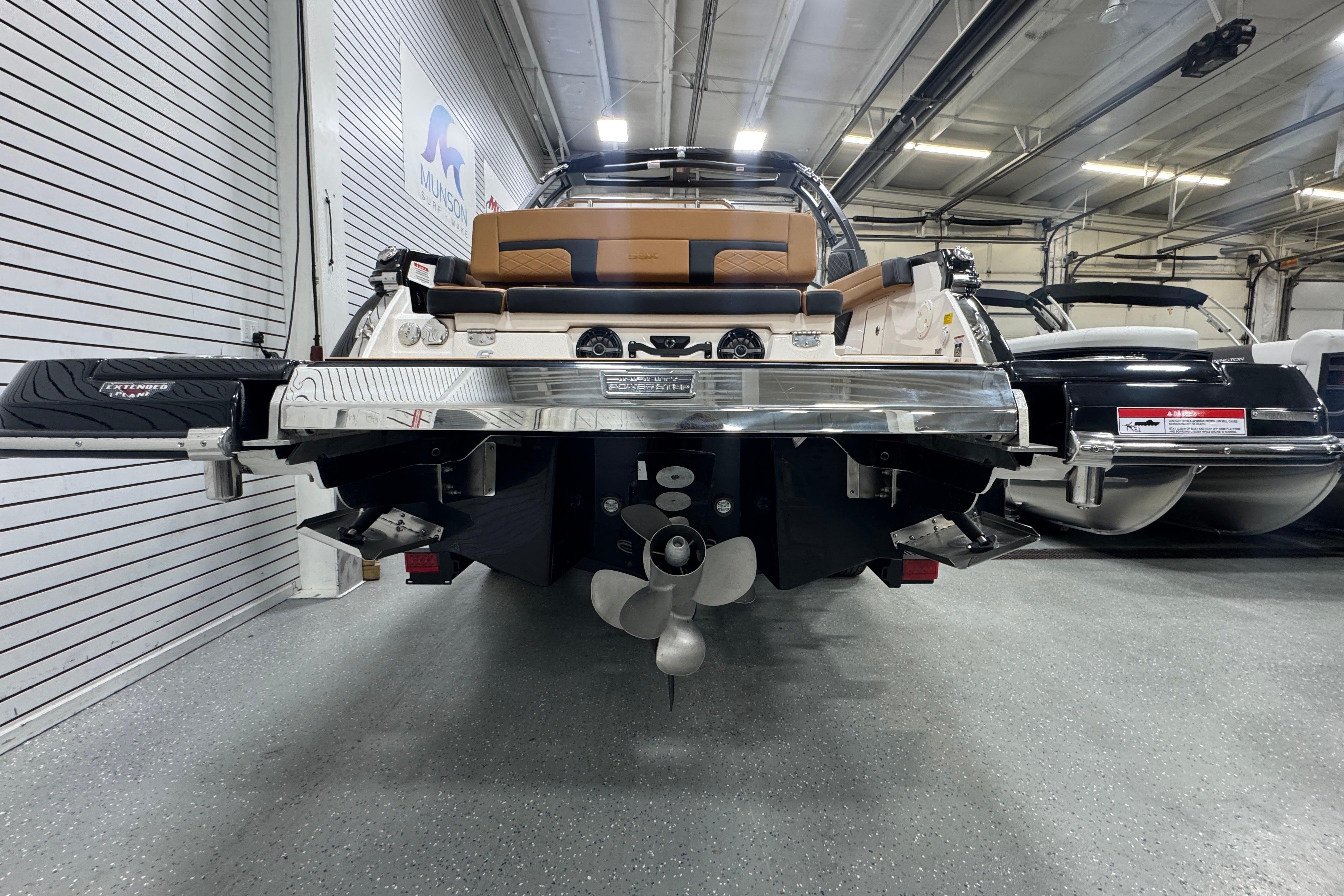 2026 Chaparral 6 SSX boat in showroom, rear view with propeller and seating.