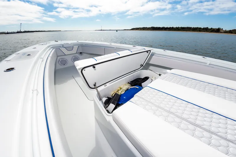 Fin Print Yacht Photos Pics 2023 Contender 44FA boat with open storage compartment, on calm water.