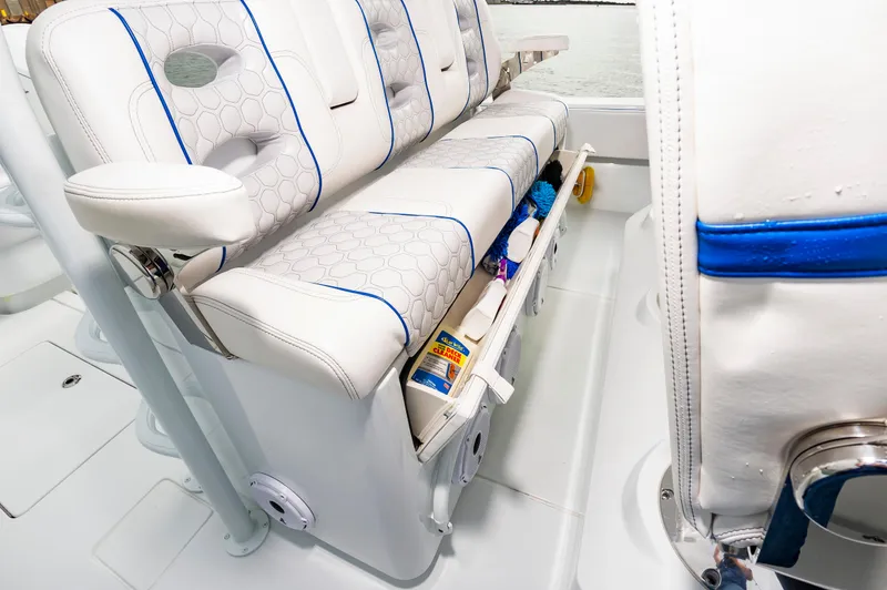Fin Print Yacht Photos Pics 2023 Contender 44FA boat seating with storage compartment, featuring white upholstery and blue accents.