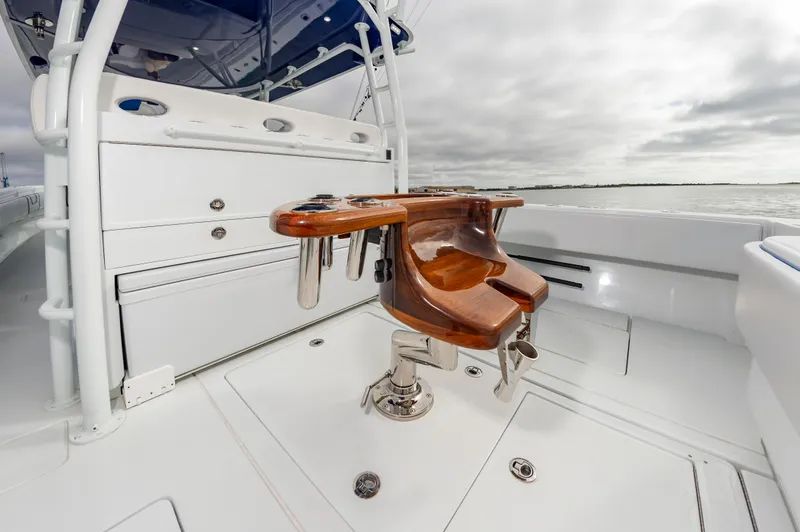 Fin Print Yacht Photos Pics 2023 Contender 44FA boat with wooden fighting chair on deck, under cloudy sky.