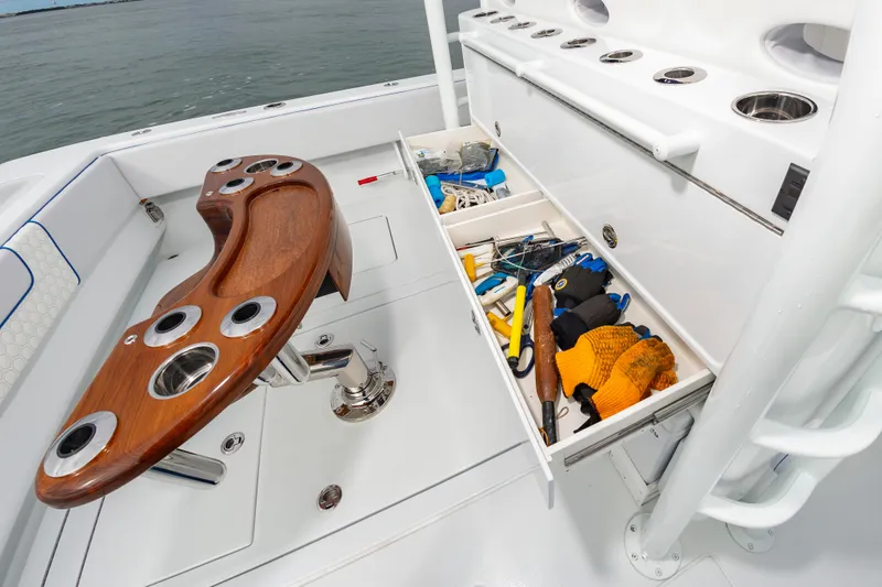 Fin Print Yacht Photos Pics 2023 Contender 44FA boat with fishing rod holders and storage drawers open, revealing tools and gloves.