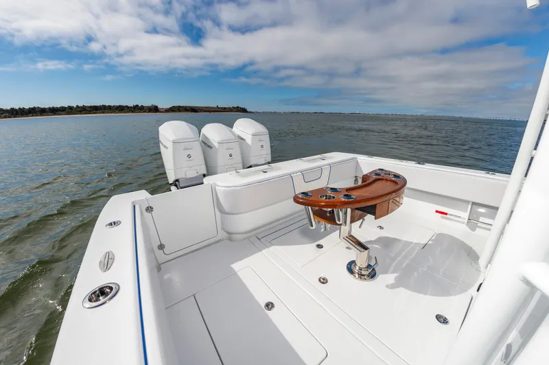 Fin Print Yacht Photos Pics 2023 Contender 44FA boat with triple engines, spacious deck, and fishing chair on open water.