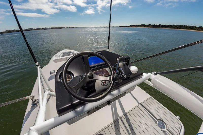 Fin Print Yacht Photos Pics 2023 Contender 44FA boat helm with steering wheel and controls on open water.