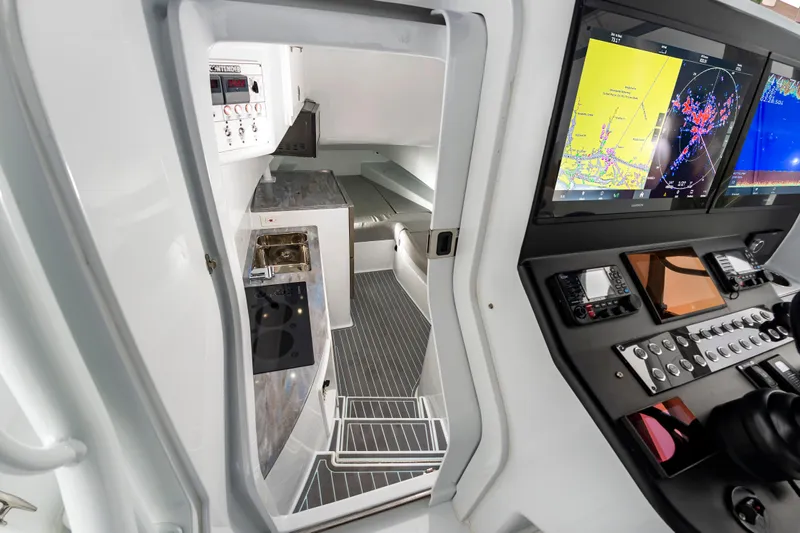Fin Print Yacht Photos Pics Interior of 2023 Contender 44FA boat with navigation screens and compact cabin amenities.