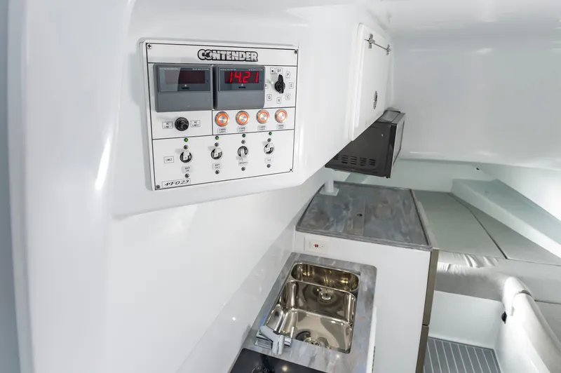 Fin Print Yacht Photos Pics Interior of 2023 Contender 44FA boat featuring control panel and compact kitchen area.