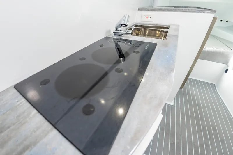 Fin Print Yacht Photos Pics Modern kitchen area in 2023 Contender 44FA boat with sleek stovetop and sink.