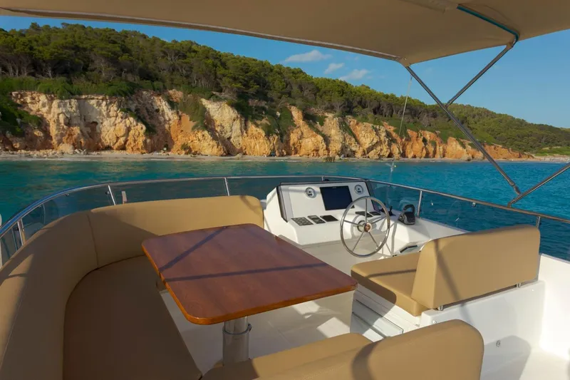  Yacht Photos Pics Luxurious 2026 Sasga Yachts 55 with scenic coastal view, featuring elegant seating and helm.