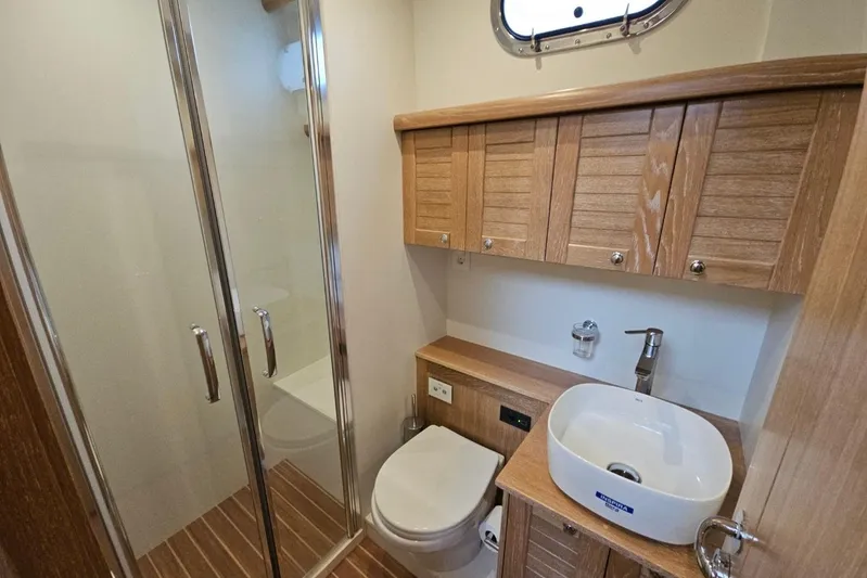  Yacht Photos Pics Luxurious bathroom in 2026 Sasga Yachts 55, featuring wood accents and modern fixtures.