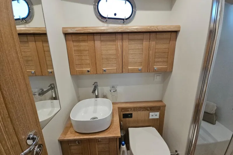  Yacht Photos Pics Bathroom interior of 2026 Sasga Yachts 55, featuring wooden cabinetry and modern fixtures.