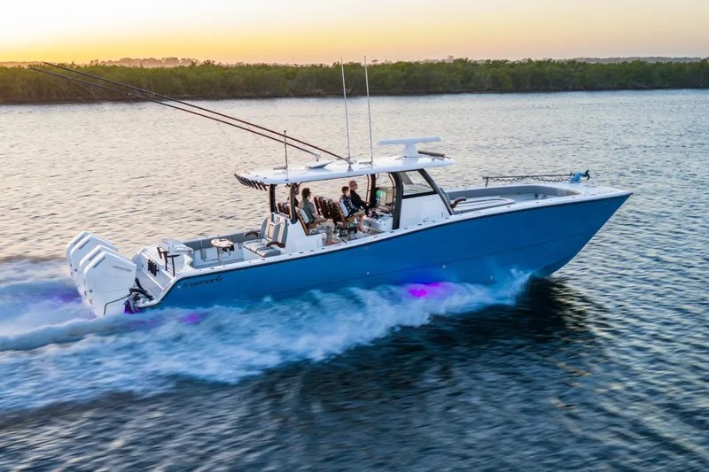  Yacht Photos Pics 2025 Freeman 43 boat cruising on water at sunset with fishing rods and passengers.